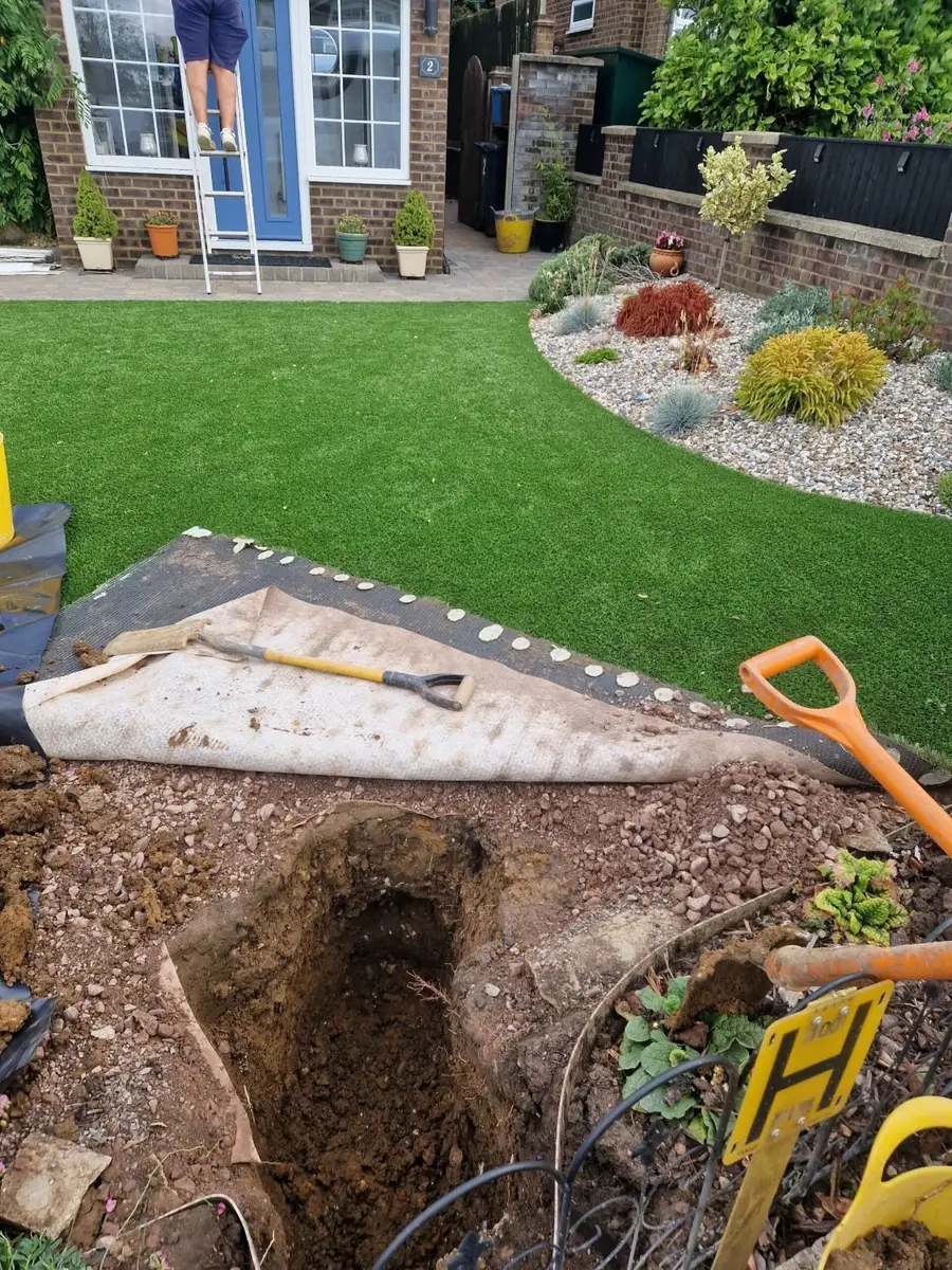 Lawn rolled back and the excavation opened for a full supply pipe replacement in Stevenage