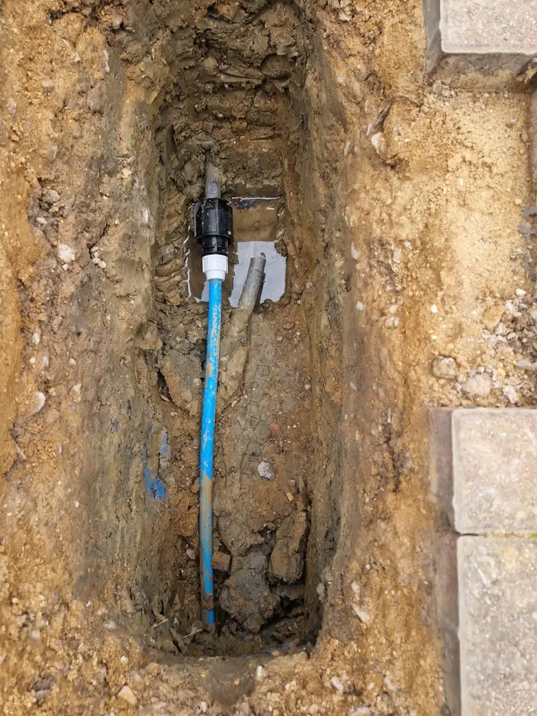 New blue MDPE supply pipe installed alongside the old pipework in an excavation at Borehamwood