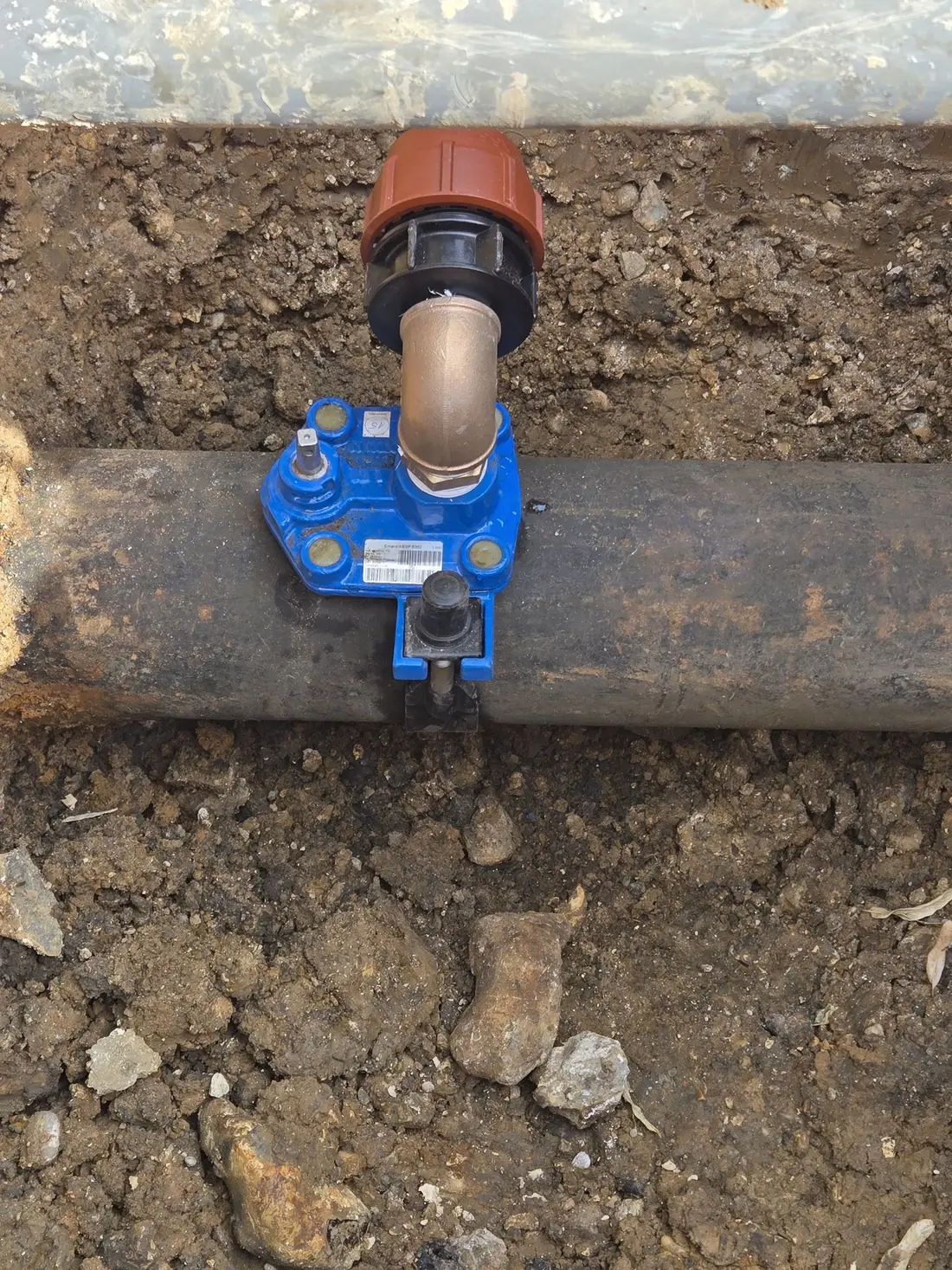 Tapping tee fitted to a live water main for an under-pressure connection