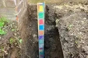 Depth of cover measured in the mains trench against a graduated staff